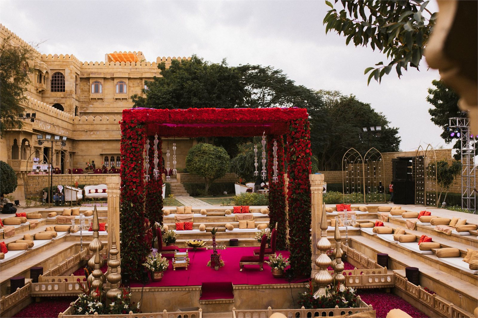 A rose-covered mandap set in the courtyard of a sandstone fort
