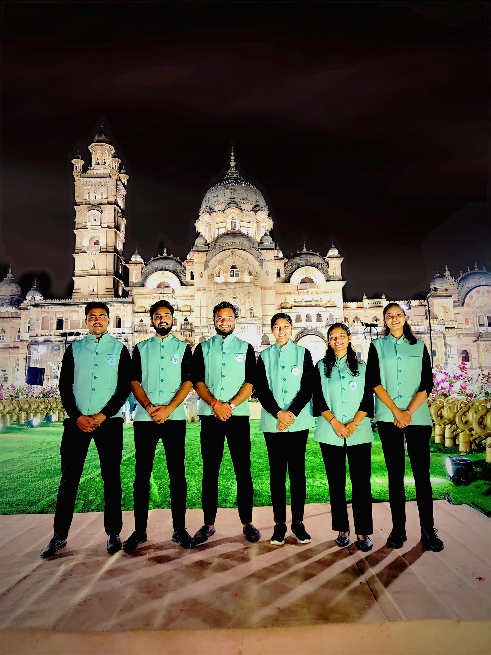 Indraa Events crew in uniform in front of a floodlit palace venue